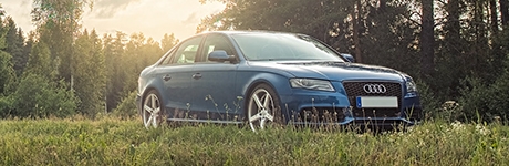 Blue Audi sedan in a field