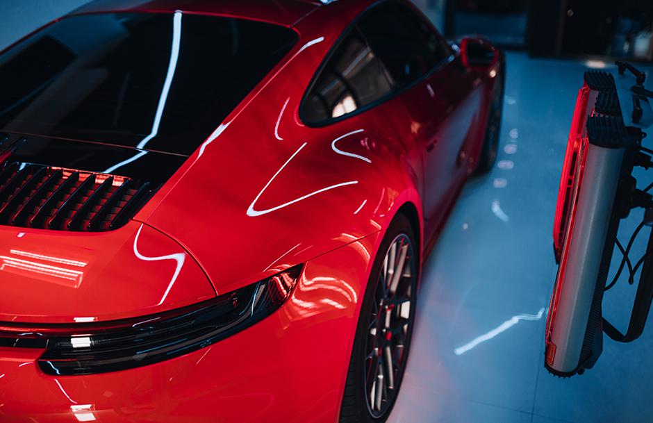 Red sports car getting custom paint wax work done