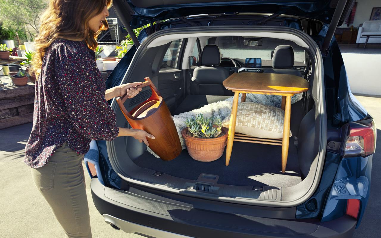 Woman putting her shopping items into the spacious trunk of a 2022 Ford Escape 