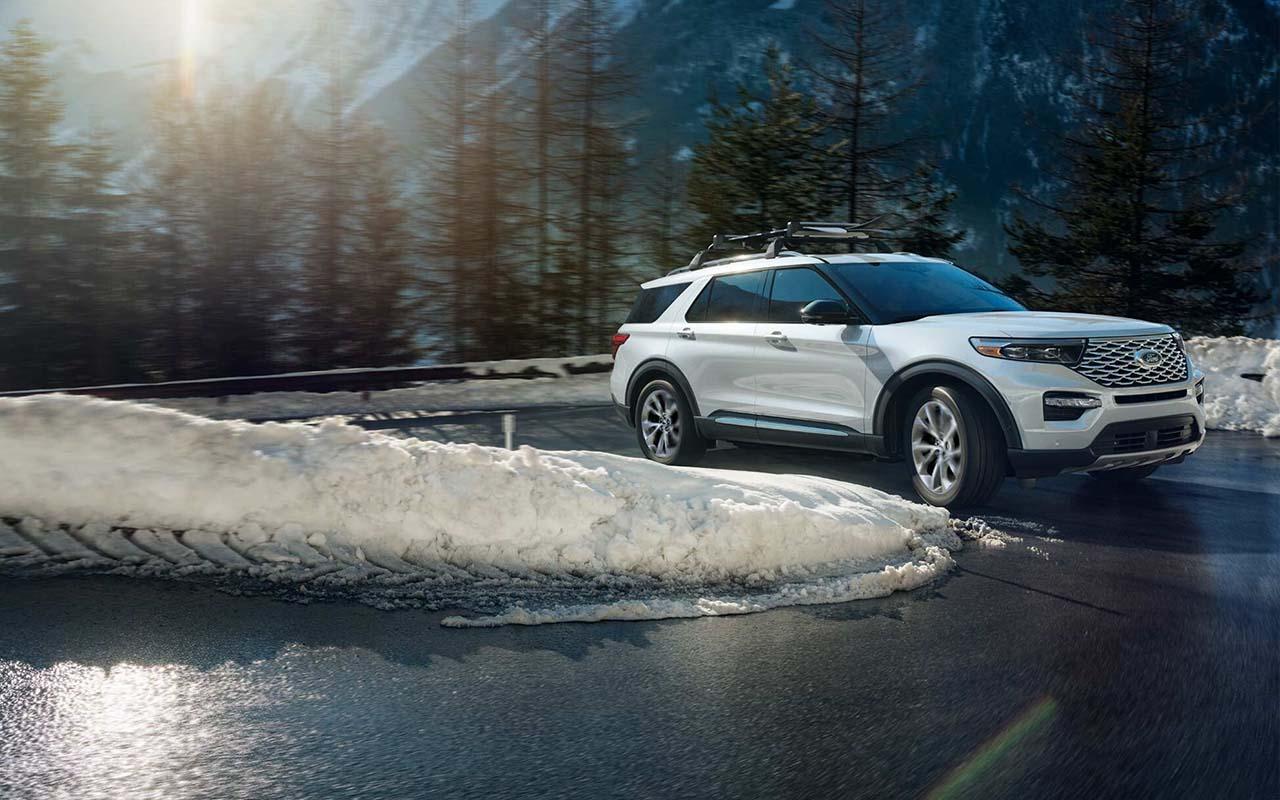 2022 Ford Explorer ST driving around a bend going up a snowy mountain