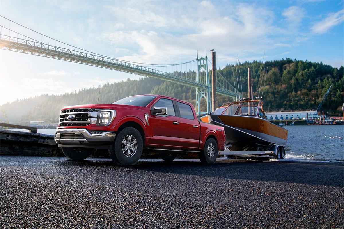 2023 FORD F-150® pulling a boat out of the water in front of a bridge | South Bay Ford