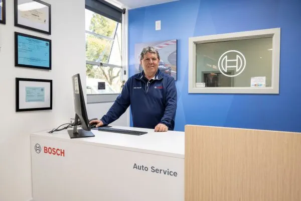 Bosch Auto Service consultant assisting technician with wheel alignment. 