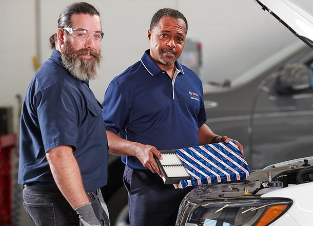 Bosch Auto Service technicians working under the hood of a vehicle