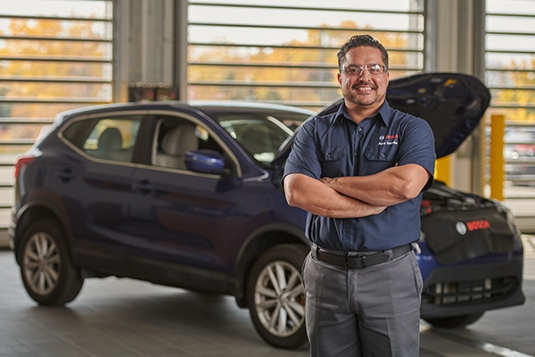 Bosch Auto Service technician standing in front of car