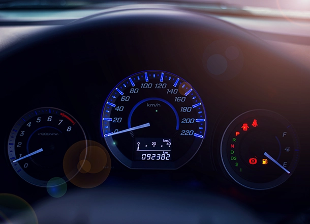 Illuminated car dashboard with warning lights and gauges