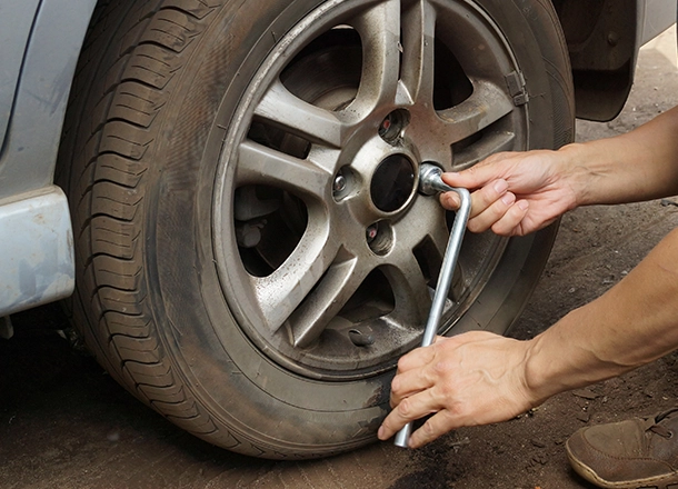 Bosch Auto Service | Man with phone looking at flat tire